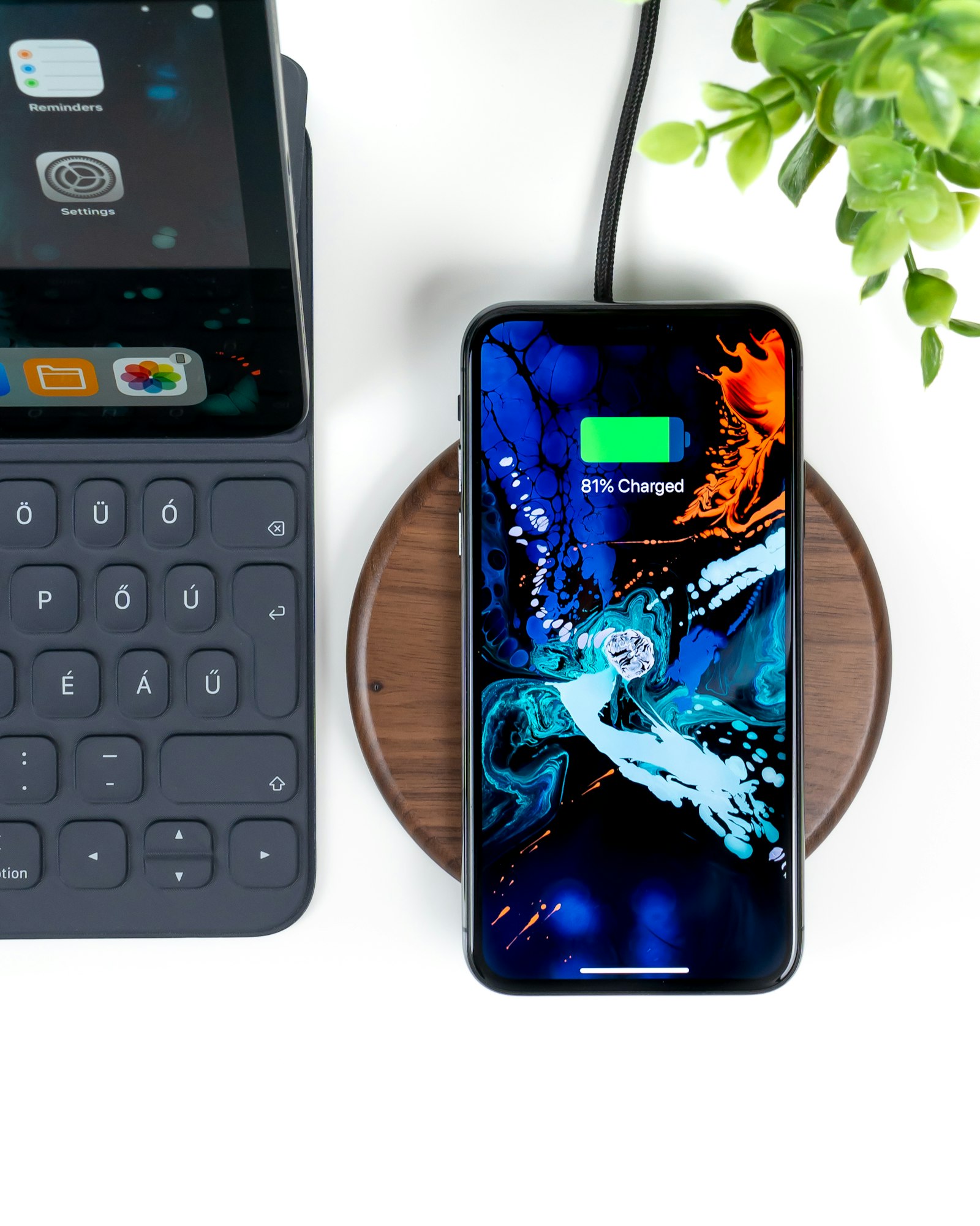 Smartphone charging on a wooden wireless charging pad showing 81 percent charged