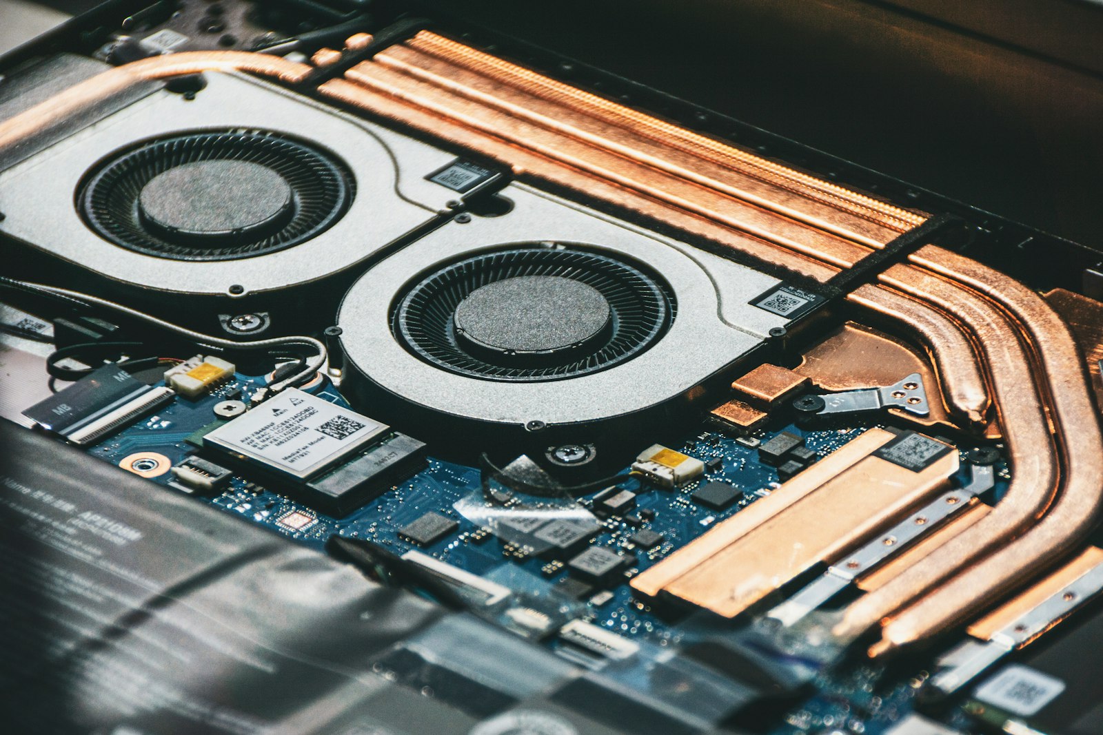 Close-up of a laptop’s internal dual cooling fans and copper heat pipes